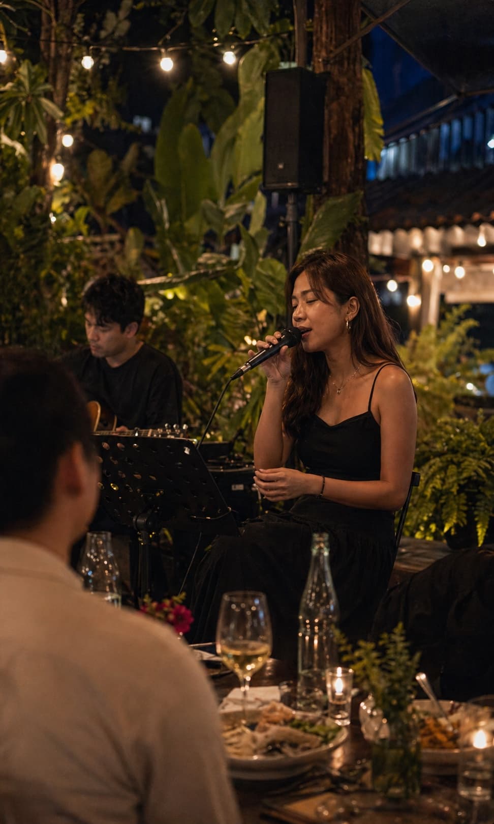 Singer performing an acoustic garden dinner set.